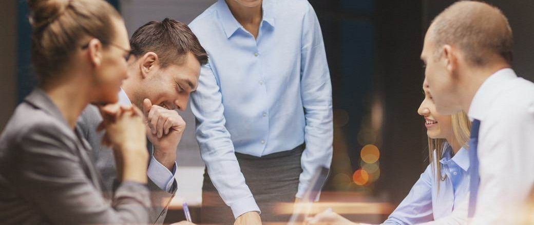 Smiling female boss talking to business team