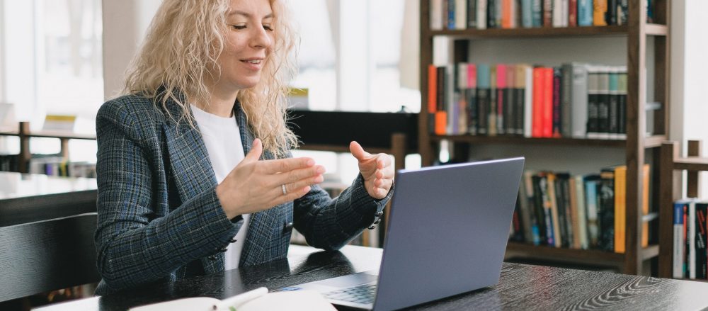 A woman teaching an online course, speaking to her laptop's webcam