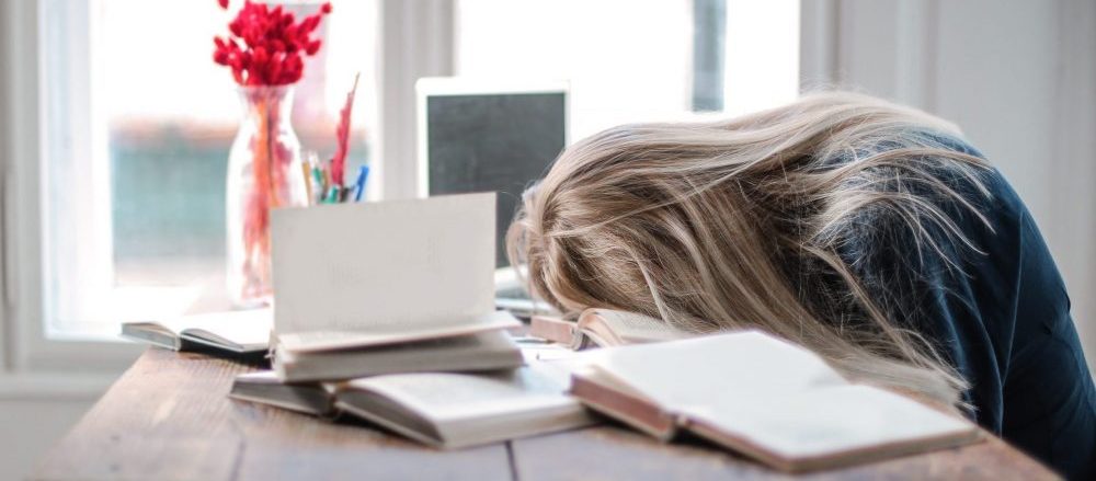 A woman with her head on the desk, unengaged