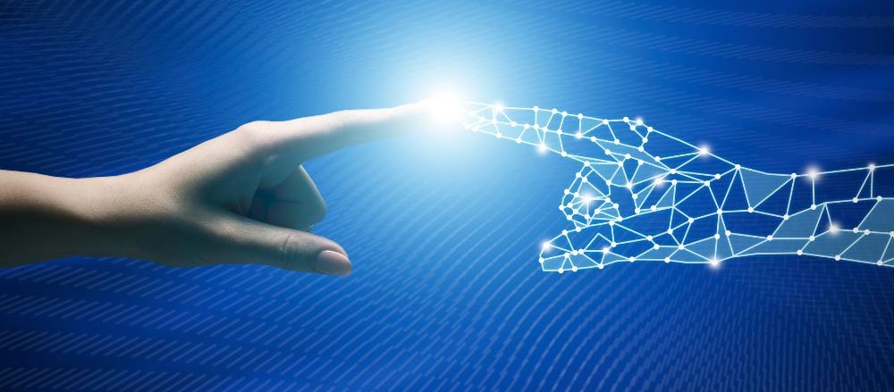 A digital hand touches fingers with a human hand.