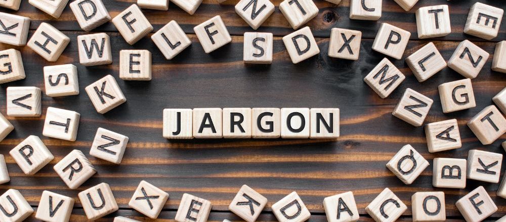 Many Scrabble tiles are scattered on a table; in the middle, they spell out "Jargon"